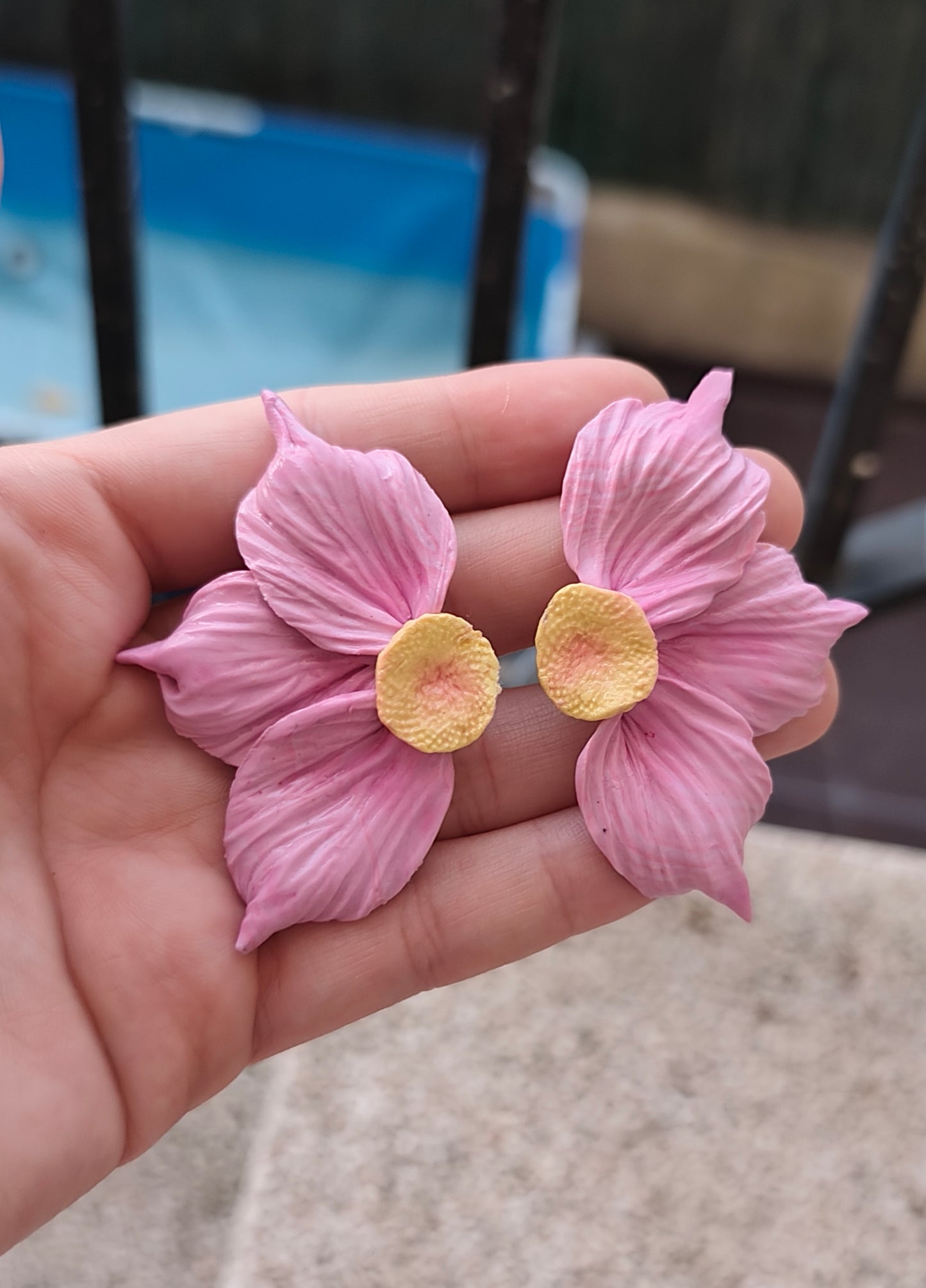 Pendientes maxi flor rosa en mano, detalle pétalos